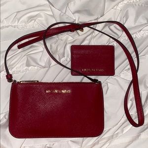 A Red Michael Kors crossbody purse and wallet.